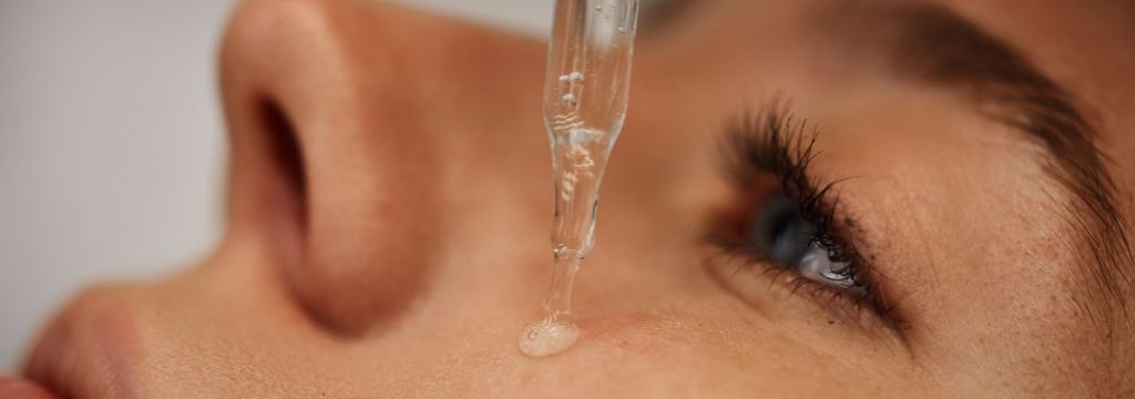 Mulher aplicando sérum de vitamina c facial em sua pele como parte de uma rotina de cuidados